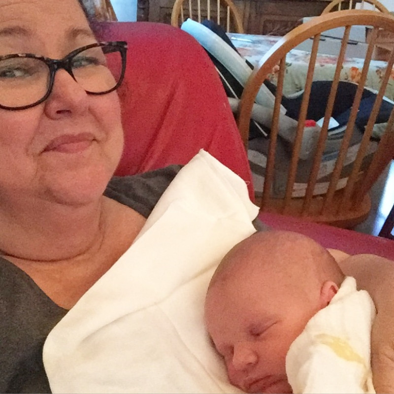 A grandmother holding her newborn grandson.