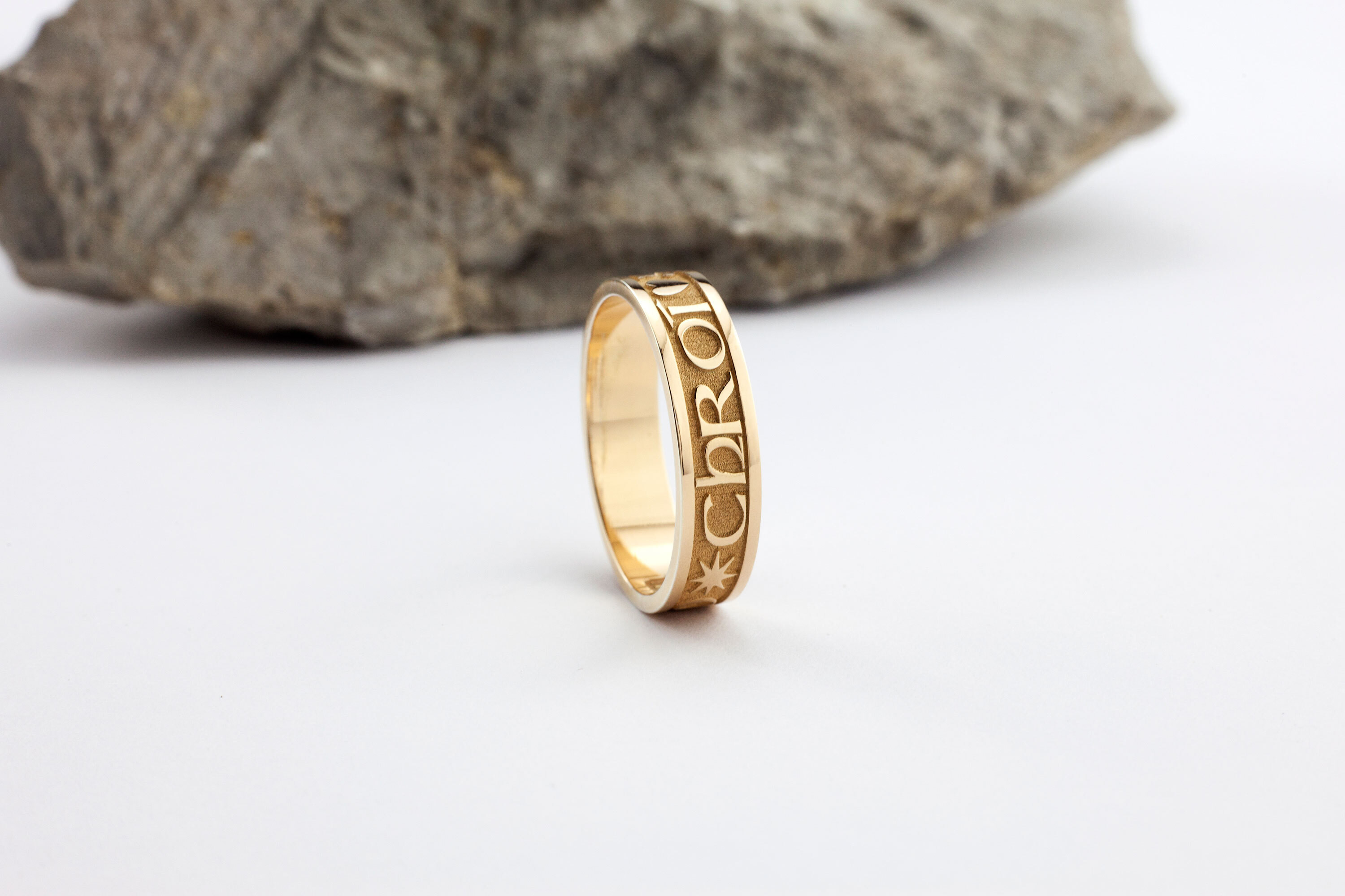 alt text: A gold ring with the phrase &quot;Gra Geal Mo Chroi&quot; engraved around it.